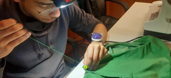 Couture à la main du bouton à l'arrière de la robe.