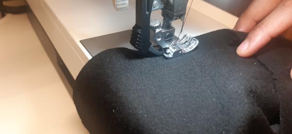 Ici, je couds un point de bâti. Ce point me sert à gérer l'excès de tissu sur le contour de la manche plus aisément, car je peux tirer dessus comme sur un lacet et ainsi resserer le tissu.