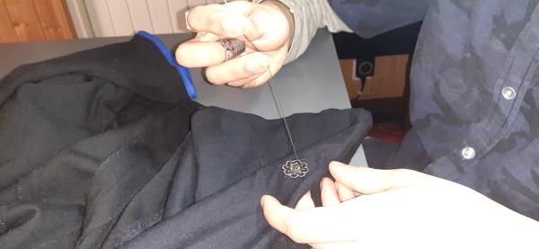 Comme on peut le voir sur cette image, j'ai précédemment cousu du biais bleu sur le bout des manches.<br>Et aussi, je couds les boutons pression. Les boutons mâle vont sur la doublure, et les boutons femelle sur l'extérieur de la veste, de l'autre côté (non visible sur l'image).
