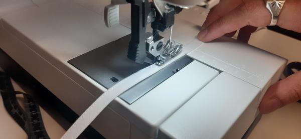 J'ai aussi pris l'initiative de placer un faux lacet devant la bande de taille de la jupe. Ici, je suis en train de le confectionner à base de biais blanc.