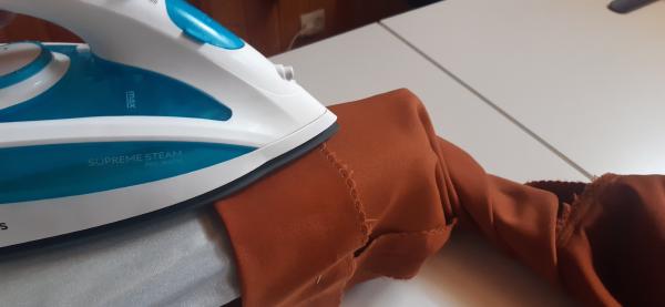 Repassage des ourlets des manches. À ce stade, ils n'ont pas encore été cousus.