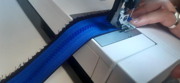 Couture de la fermeture éclair sur la partie centrale intérieure de la braguette.