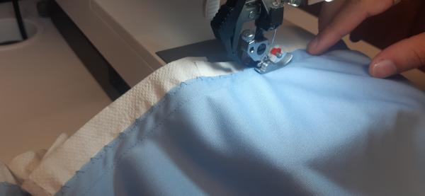 Surjet des bords du jupon. J'utilise du sopalin afin de donner plus de tenue au tissu. Autrement, il risque de se déteriorer lors de la couture.<br>Une fois cousu, il suffit d'arracher le sopalin autour des points de couture.